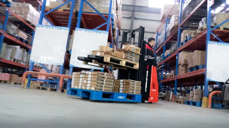 Xe nâng điện đứng lái RSi201 đang nâng pallet hàng trong kho cao